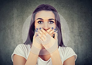 Scared woman covers her mouth to keep it quiet