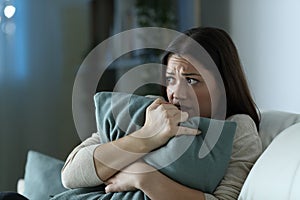 Scared woman embracing pillow at home in the night