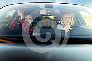 Scared woman and instructor in car, front view