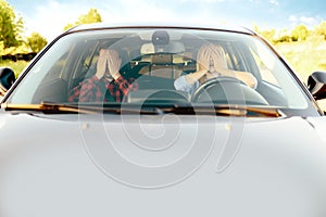 Scared woman and instructor in car, front view