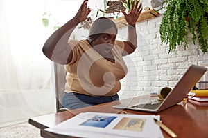 Scared woman looking on spilled coffee on laptop