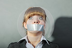 Scared woman with mouth taped shut. Censorship.