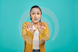 Scared woman portrait, blue background, emotion