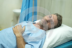 Scared and worried man hospitalized - attractive injured man lying on hospital bed receiving treatment feeling sick after