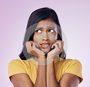 Scared, worry and face of Indian woman on pink background with fear, nervous and confused expression. Stress, anxiety
