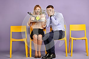 Scared young blonde woman and young man sitting together
