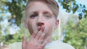 Scared young male covering mouth by hand, child feeling scared, shocking news