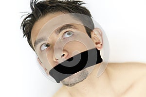 Scared young man with bandage on mouth