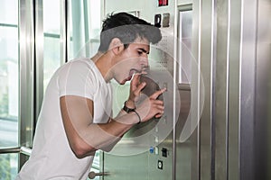Scared young man desperate in stuck elevator