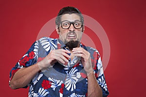 Scared young man in Hawaiian shirt looking at camera