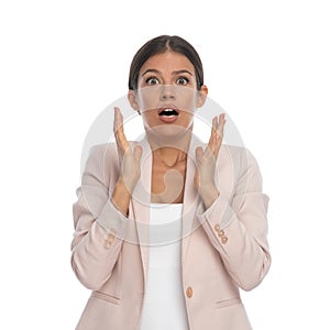 Scared young woman holding hands up, opening mouth and screaming photo
