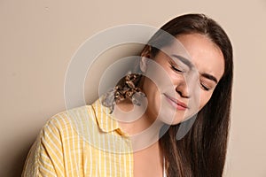 Scared young woman with tarantula on beige. Arachnophobia fear of spiders