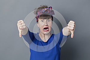 Scared young woman with thumbs down in foreground screaming