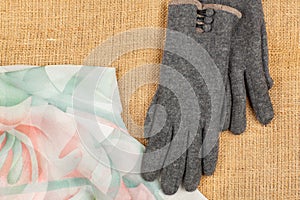 Scarf and gloves isolated on linen background.