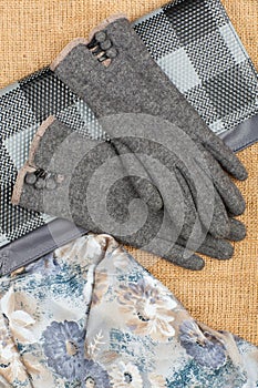 Scarf, handbag and gloves isolated on linen background.