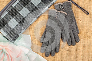 Scarf, handbag and gloves isolated on linen background.