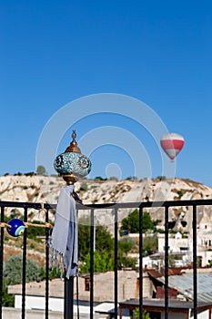 Scarf tied to a turkish lamp on the balcony. on a blurred balloon background. cappadocia