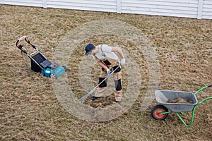 Scarifying lawn with rake and scarifier, Man gardener scarifies the lawn and removal of old grass