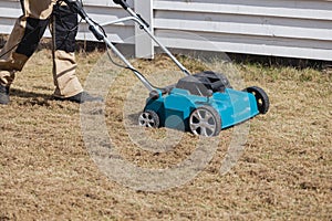 Scarifying lawn with scarifier, Man gardener scarifies the lawn and removal of old grass