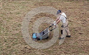 Scarifying lawn with scarifier, Man gardener scarifies the lawn and removal of old grass