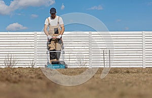 Scarifying lawn with scarifier, Man gardener scarifies the lawn and removal of old grass
