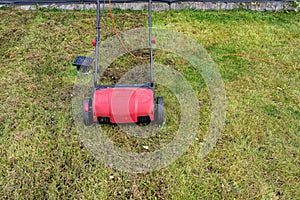 Scarifying the lawn before the winter season using an electric scarifier.