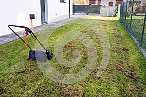 Scarifying the lawn before the winter season using an electric scarifier.