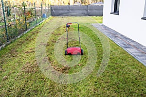 Scarifying the lawn before the winter season using an electric scarifier.