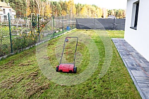 Scarifying the lawn before the winter season using an electric scarifier.