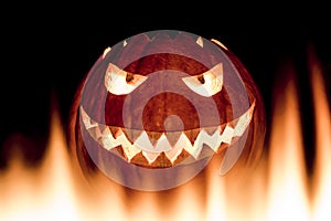 Scary carved halloween pumpkin in hot burning hell fire flames