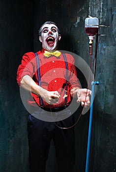 The scary clown and drip with blood on dack background. Halloween concept