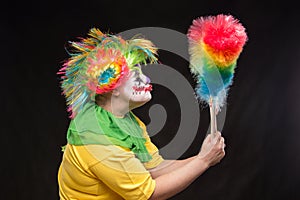 Scary clown with mohawk and a smile with a lollipop on a black b