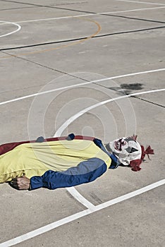 Scary clown on an outdoor basketball court