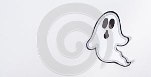 A scary but cute paper ghost with a face confuses on a white background, a place for text