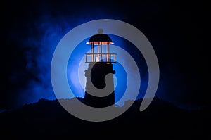 Scary dark ominous lighthouse behind a red fire background. Lighthouse at dusk/ Sunset Light House/ Light house at sunset. Decorat