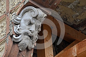 Scary decorative ancient greek head plaster placed on column eclectic styled building in Komarno, southern Slovakia