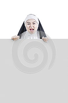 Scary devil nun holding empty whiteboard