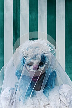 Scary evil clown in a bride dress in the circus