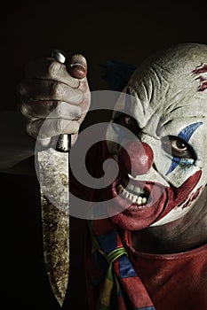 Scary evil clown with a knife