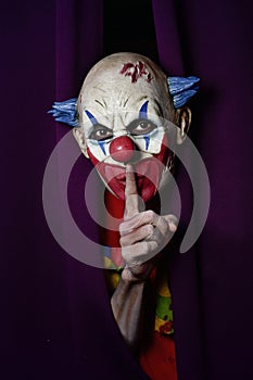 Scary evil clown asking for silence