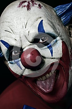Scary evil clown taking out his tongue