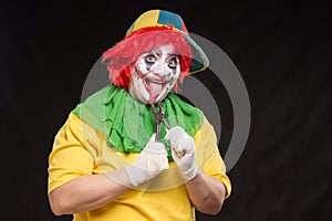 Scary evil clown with an ugly smile and a pair of pliers on a bl