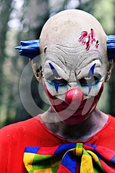 Scary evil clown in the woods