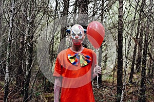 Scary evil clown in the woods