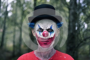 Scary evil clown in the woods