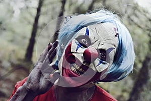 Scary evil clown in the woods