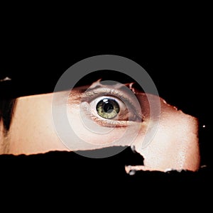 Scary eye of a man spying through a hole