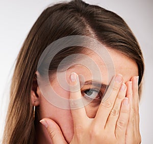 Scary, face and woman with hands to cover or hide from surprise fail in portrait on studio background. Girl, worry and