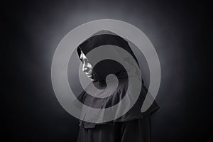 Scary figure in hooded cloak with mask photo