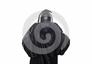 Scary figure in hooded cloak with mask in hands